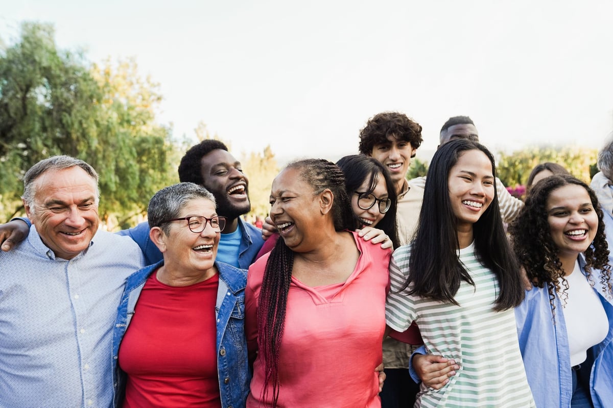 Group of multigenerational people smiling and laughing outdoor - Multiracial friends of different ages having fun together