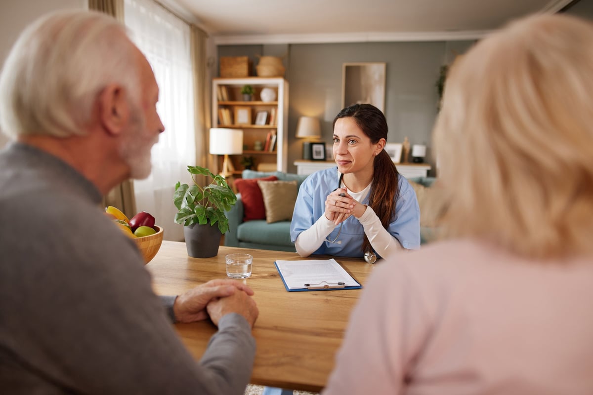Support practitioner discussing funding and support options with a person and their family, faces fully visible